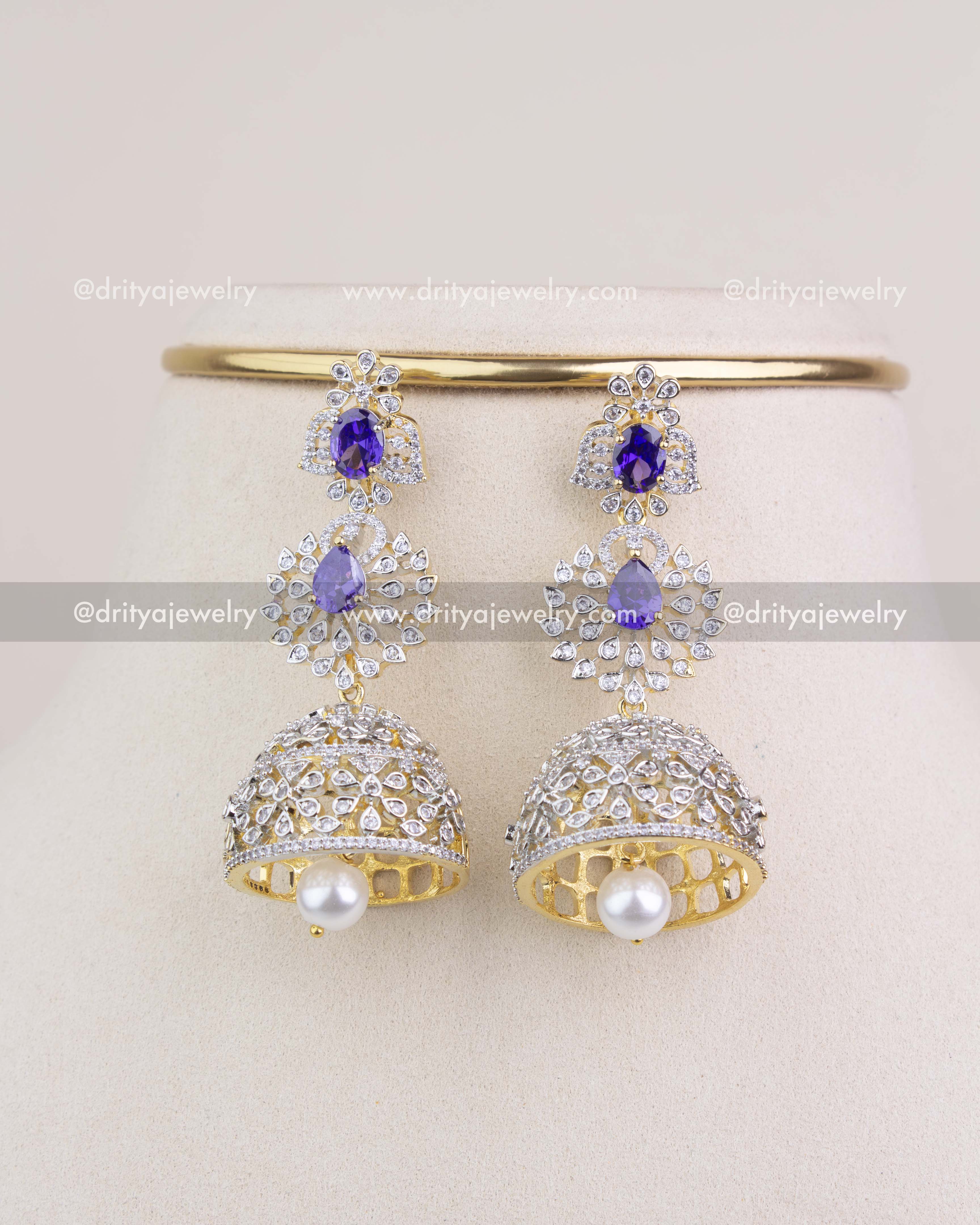 Pair of matching purple stone CZ jhumka earrings with pearl drops on display