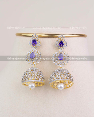 Pair of matching purple stone CZ jhumka earrings with pearl drops on display