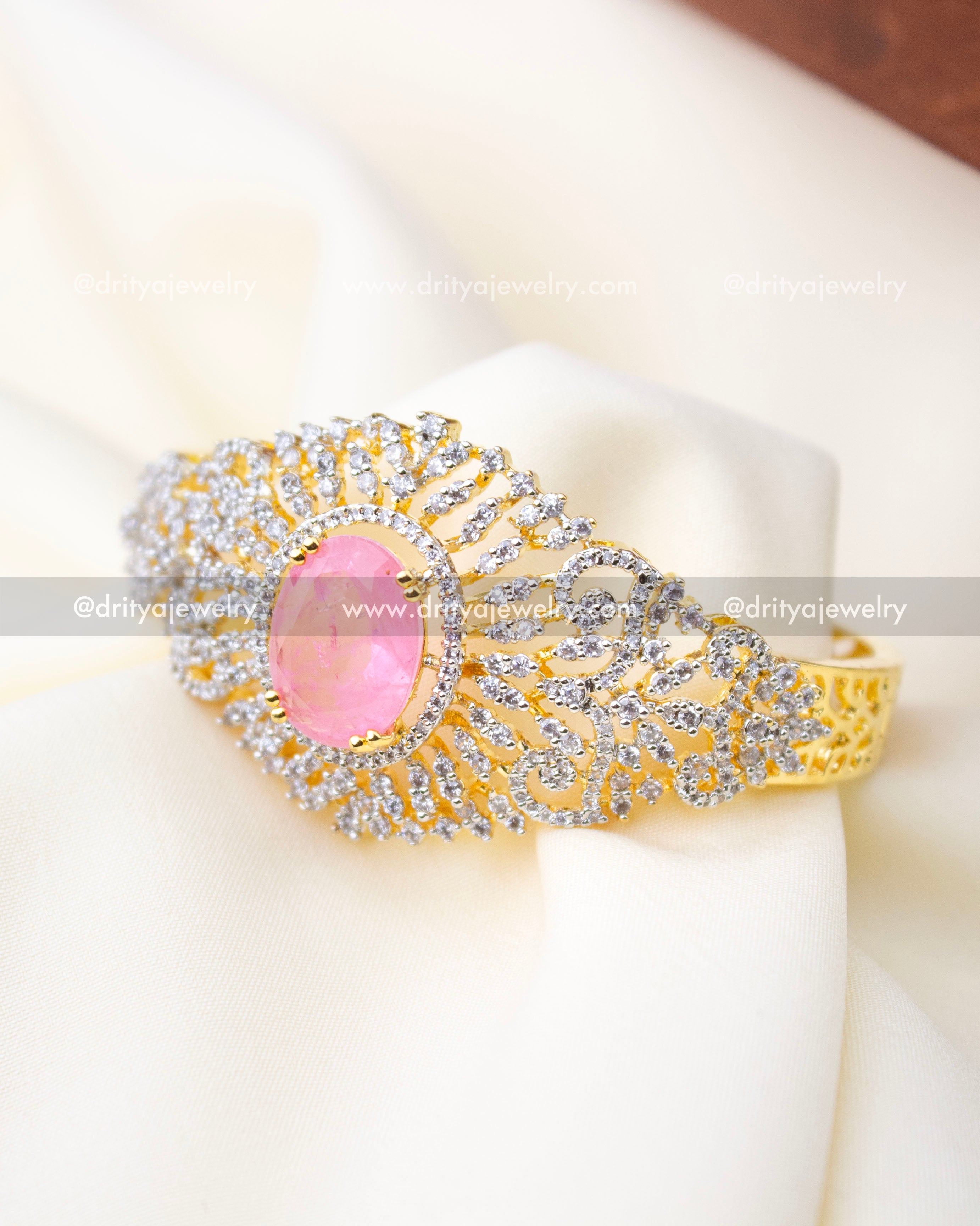 Front angled view of premium kada with crackled pink center stone and halo of sparkling stones, SKU 1295-BP