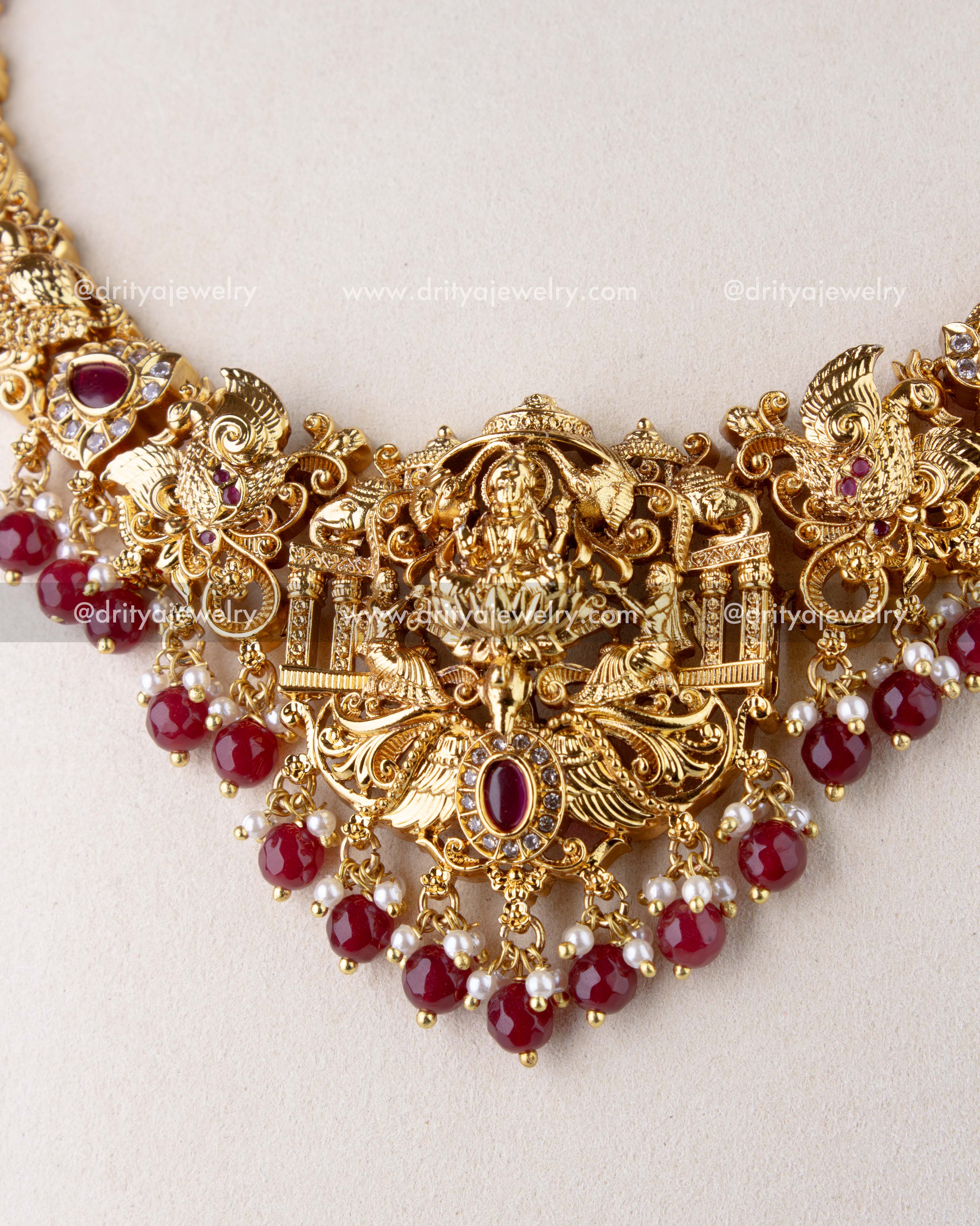 1270-R close-up of god idol pendant with ruby red bead drops and antique gold nakshi work