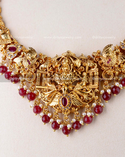 1270-R close-up of god idol pendant with ruby red bead drops and antique gold nakshi work