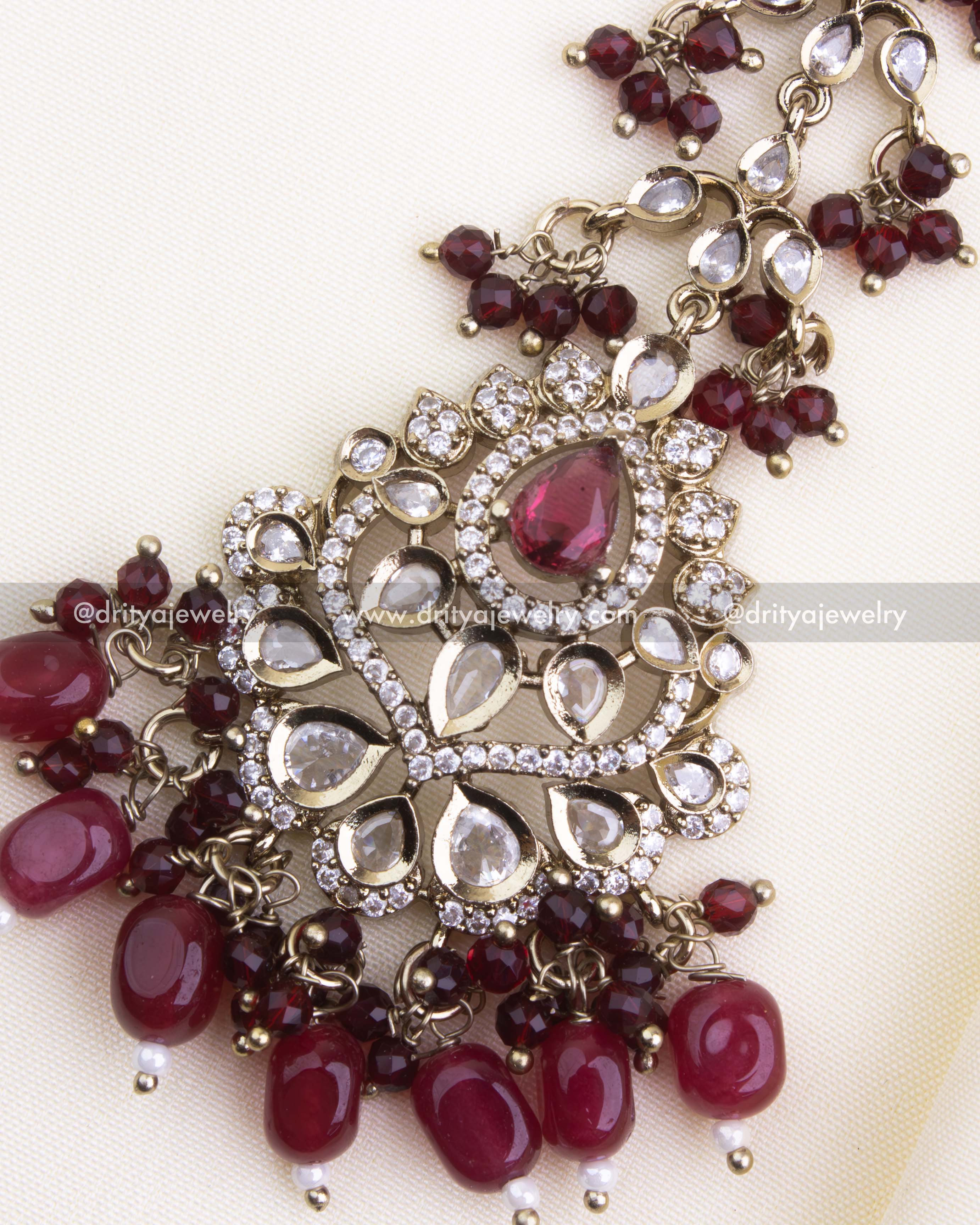 1133-R close-up of maang tikka centerpiece with red stones and gold-toned detailing