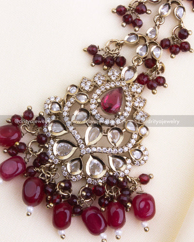 1133-R close-up of maang tikka centerpiece with red stones and gold-toned detailing