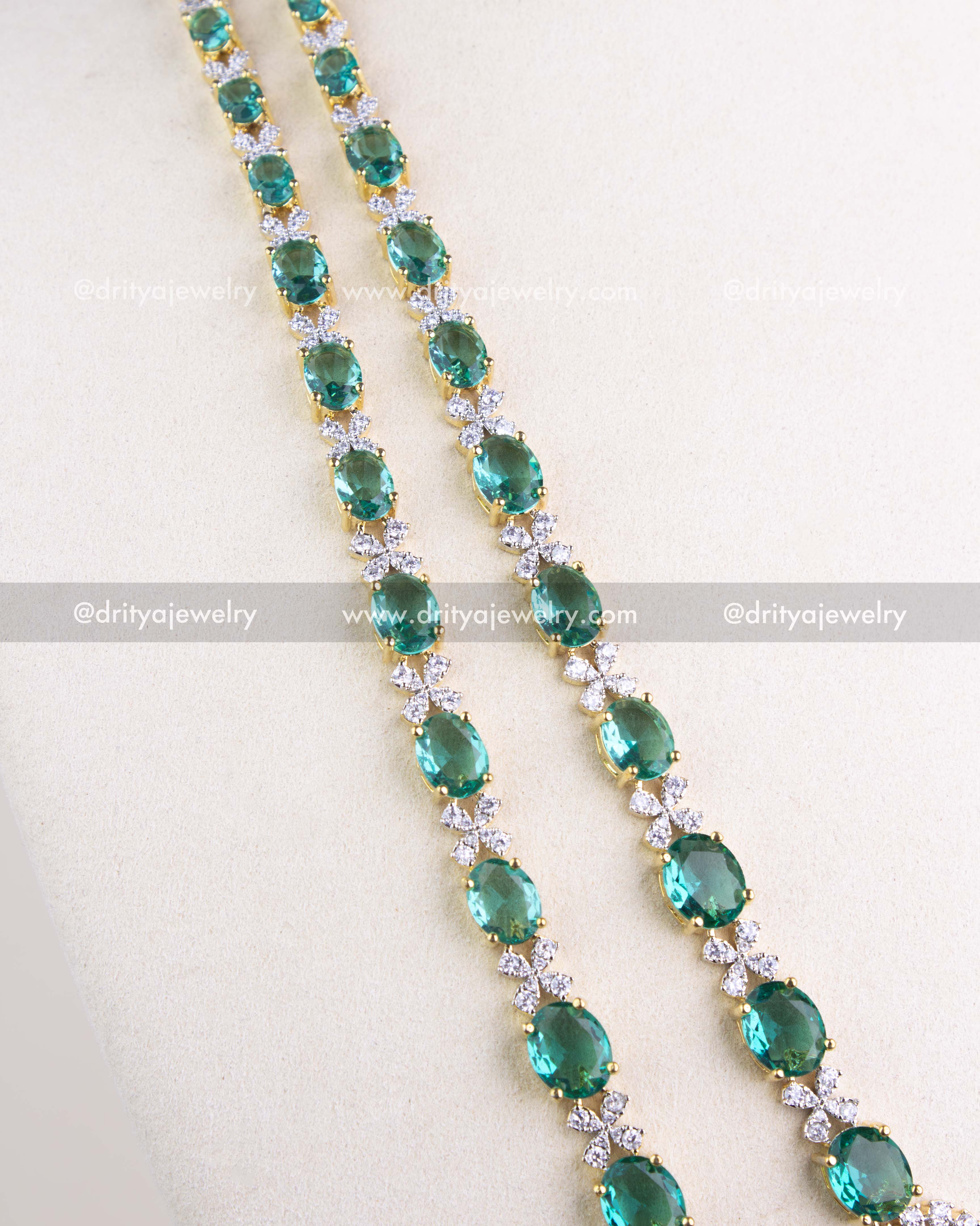 1215-RE long strands of oval emerald replica stones with CZ links in gold-toned setting