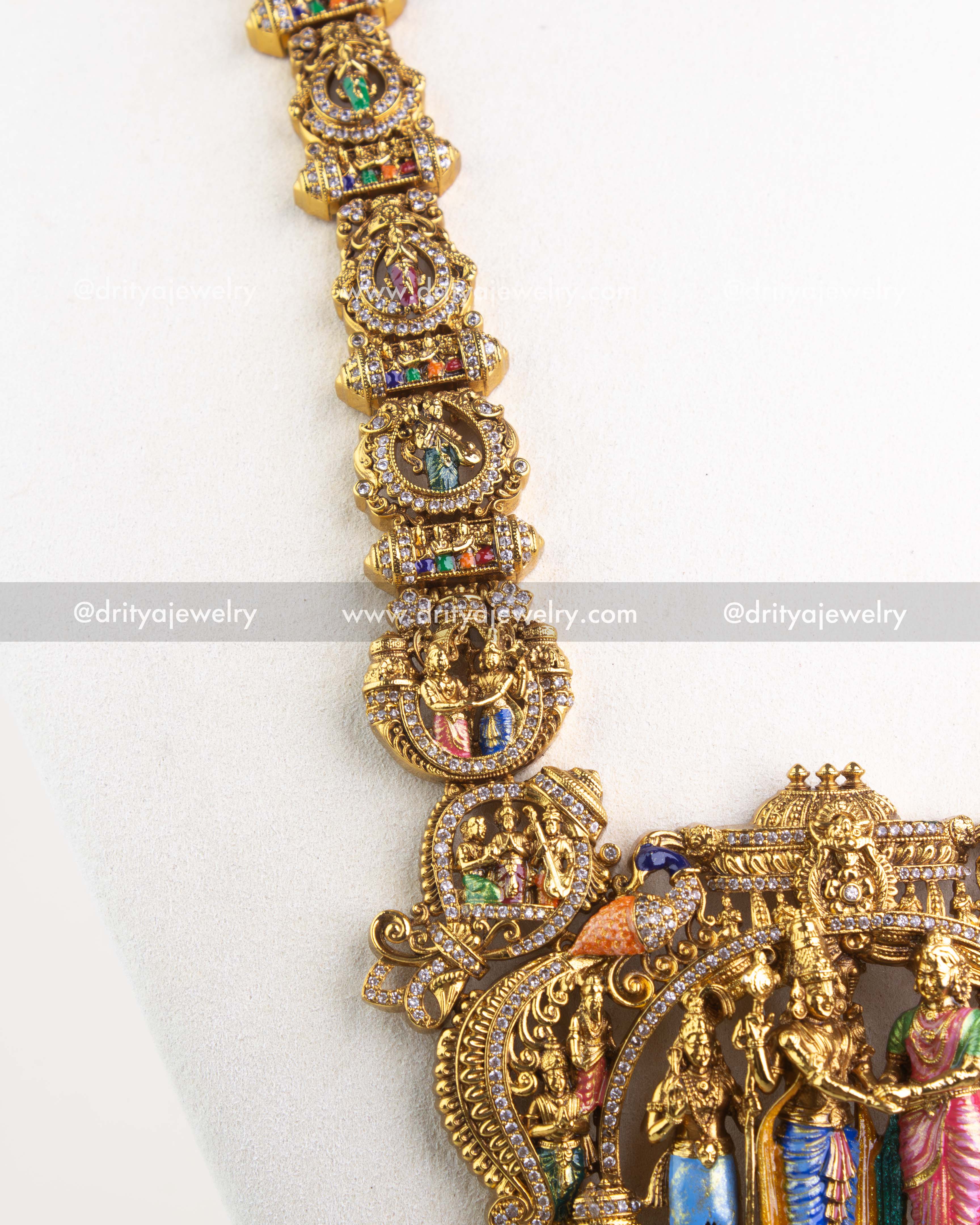 Detail of long necklace links featuring miniature deity motifs and stones