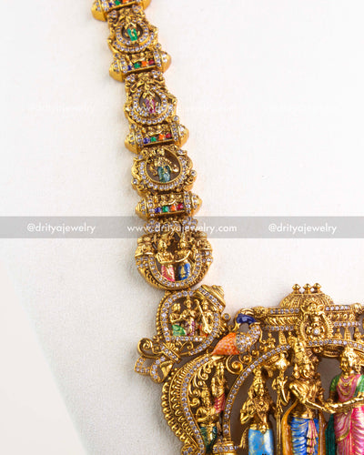 Detail of long necklace links featuring miniature deity motifs and stones