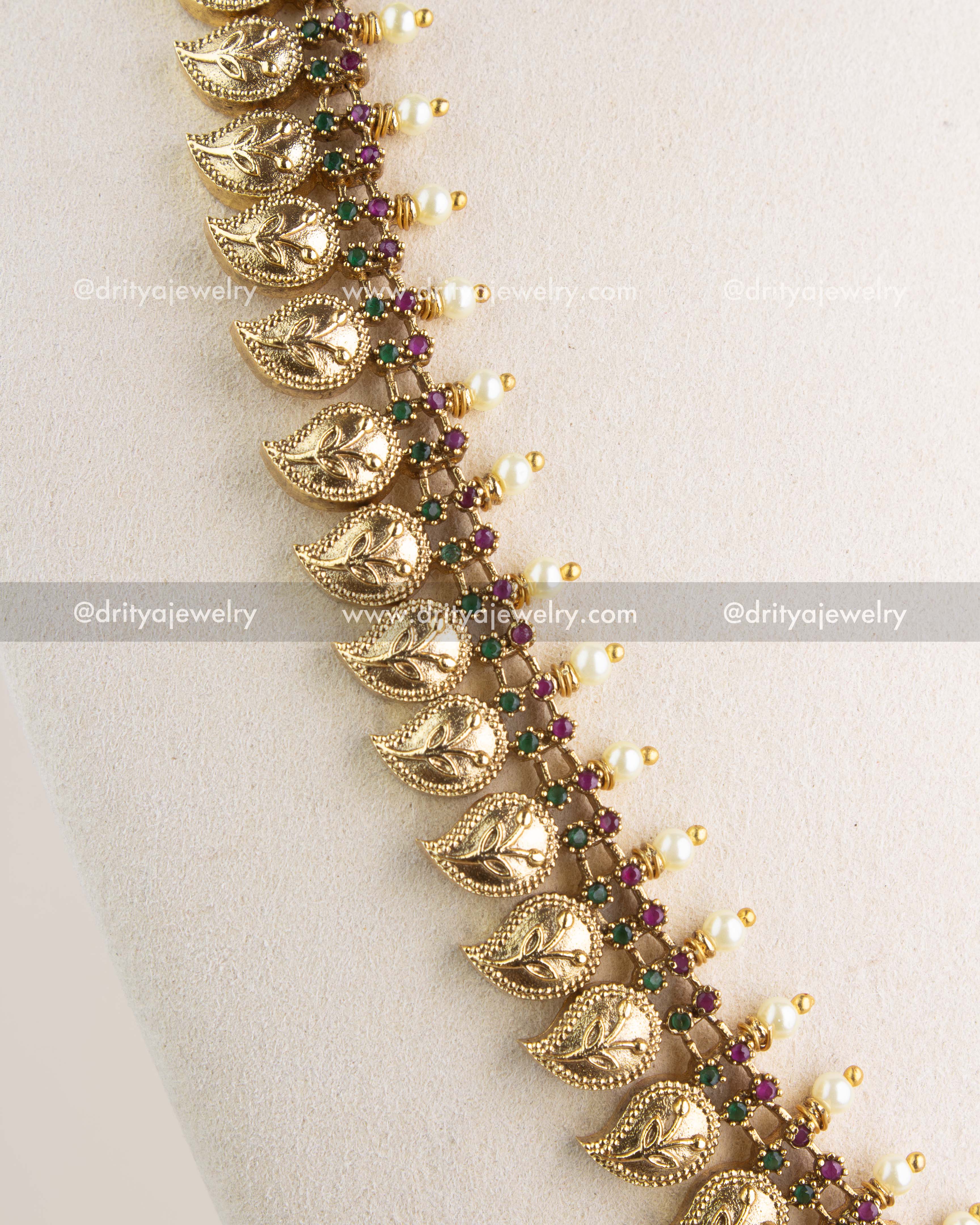 Close-up of paisley motif gold-toned necklace with ruby-green stones and pearl-like drops, SKU 1132 front detail view