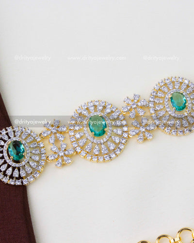 1291-RE premium diamond replica hip chain with emerald and CZ circular motifs close-up