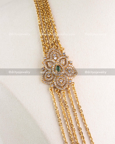Close-up of layered gold-tone chandrahaar necklace with CZ and emerald green pendant, SKU 1120-G