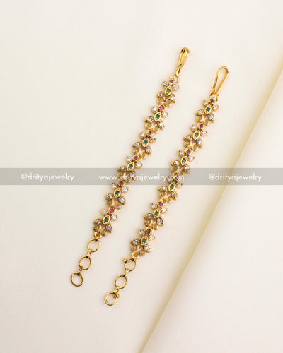 SKU 1125 full view of antique floral stone maang tikka pair laid out on fabric