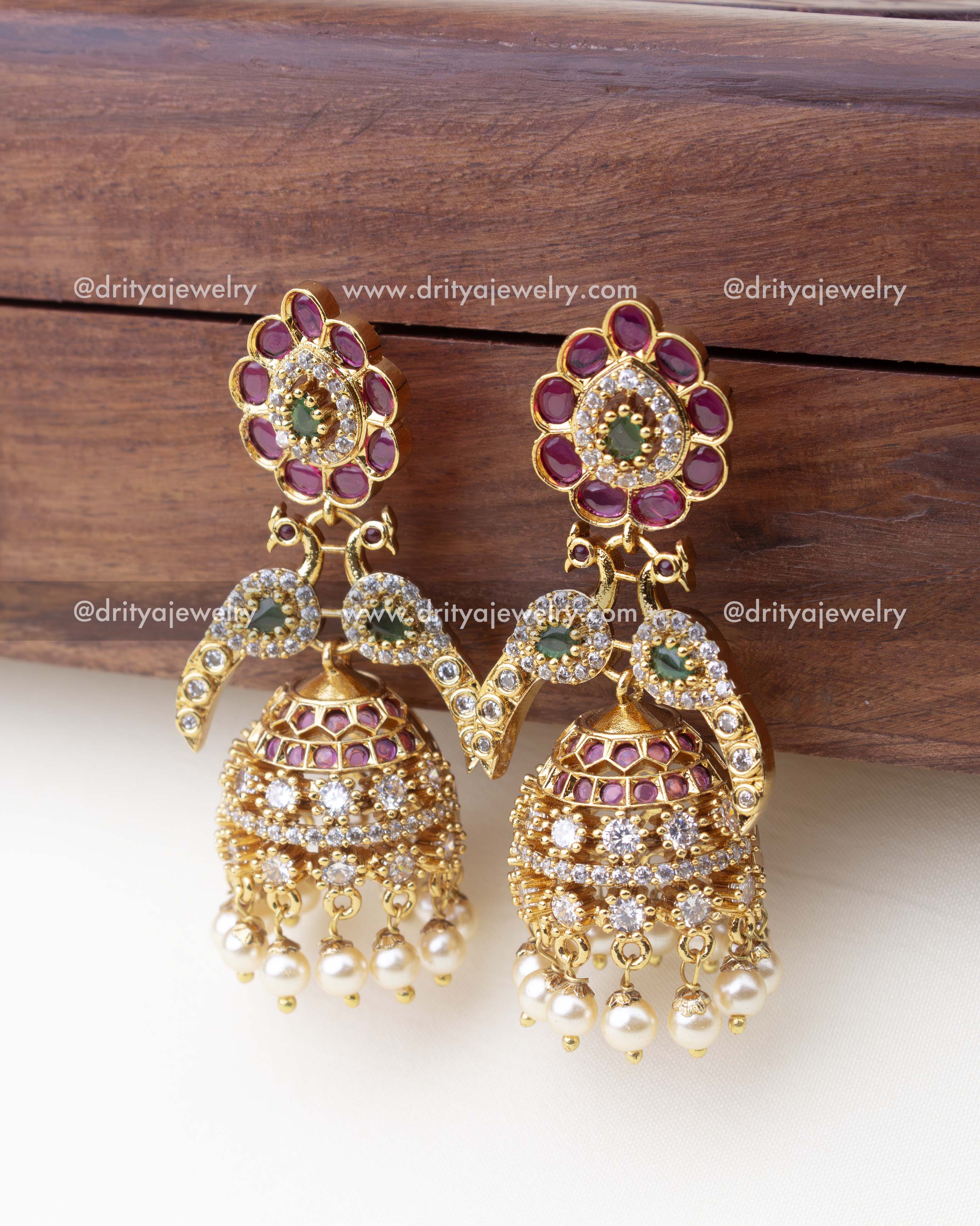 1300 - Side angle view of premium peacock design CZ jhumka earrings with pearl drops