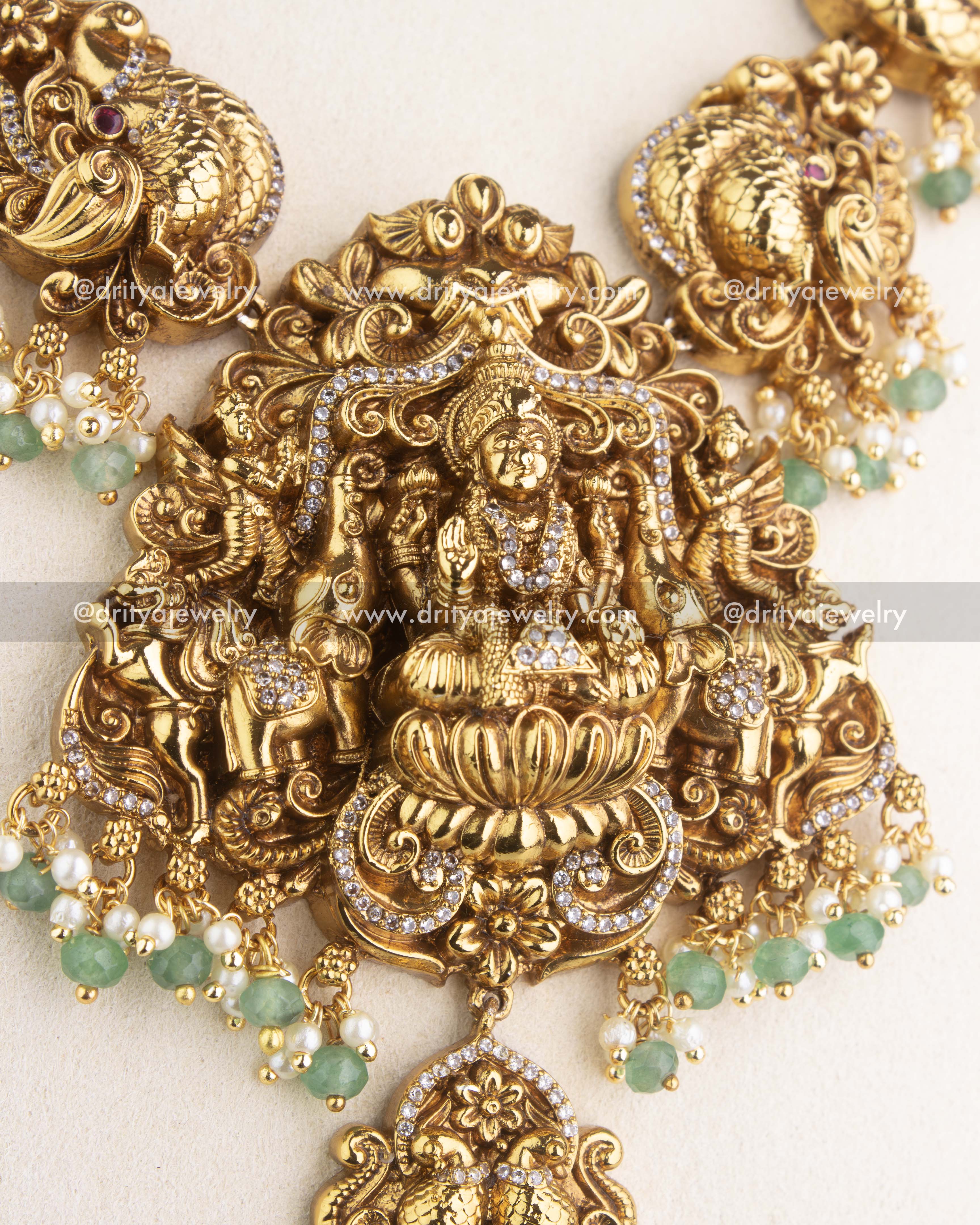 SKU 1178 Necklace Set macro shot of central god idol pendant with green and pearl-like beads