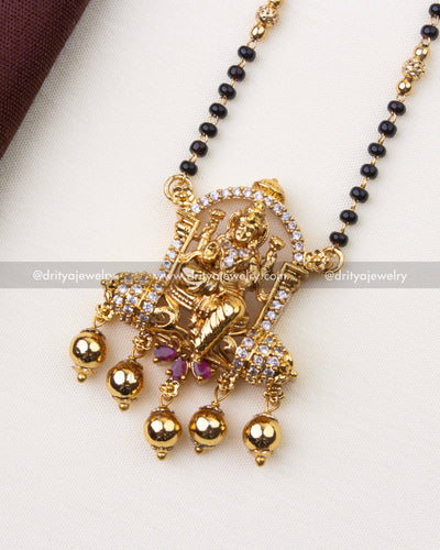 1222 - Close-up of god idol pendant with stone-studded arch and gold bead drops