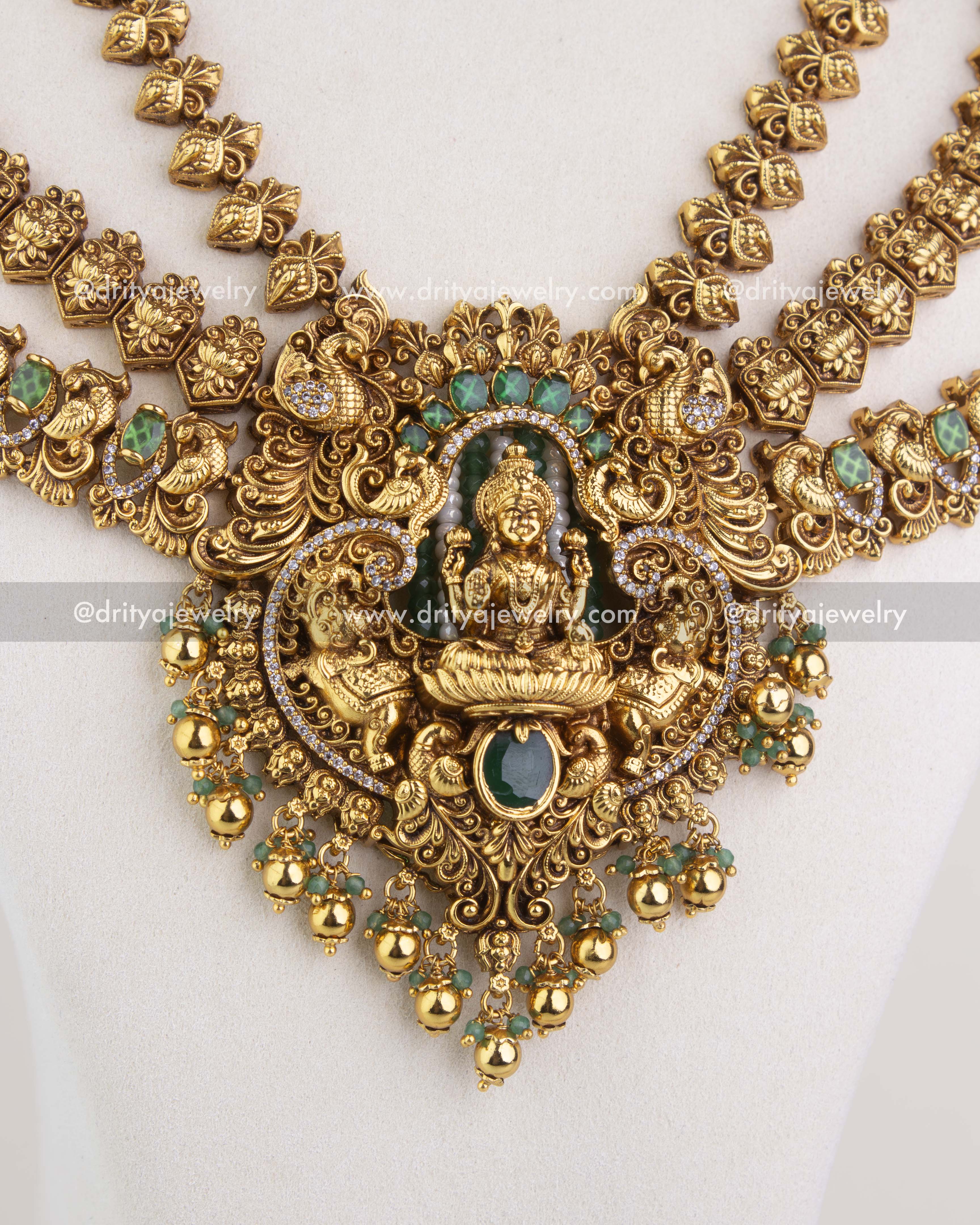 Close-up of long temple necklace pendant with Lakshmi idol and green stone detailing 1244-SET