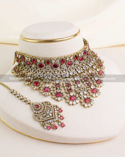 1043-R premium Victorian red stone choker necklace set with maang tikka displayed on stand