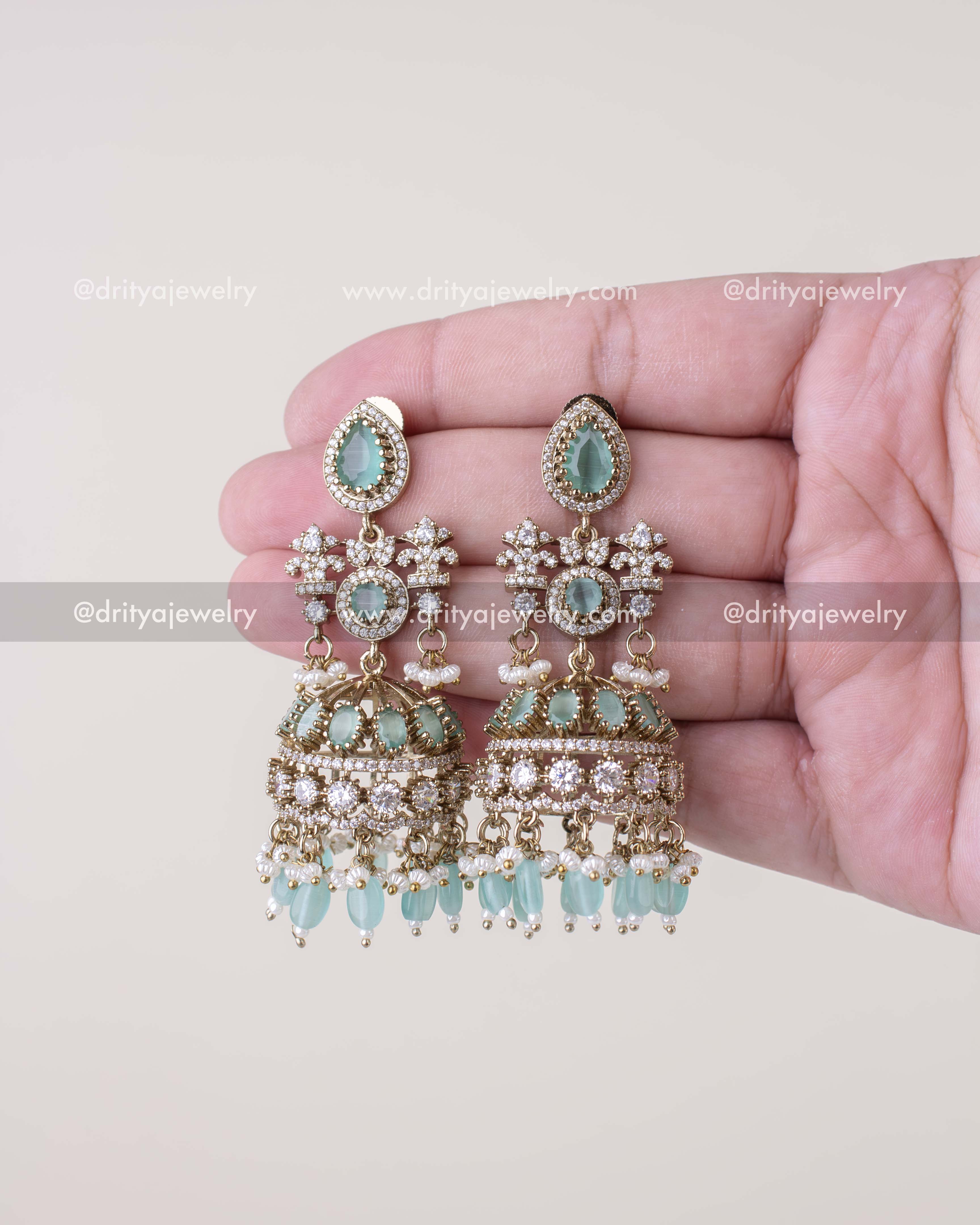 1257-MG - Full front view of mint stone Victorian bridal jhumka earrings held in hand