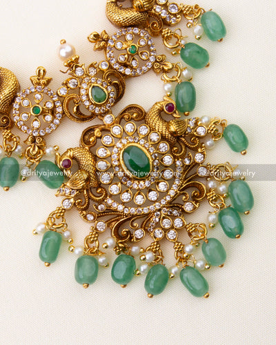 SKU 1192 close-up of antique gold idol motif necklace pendant with green beads