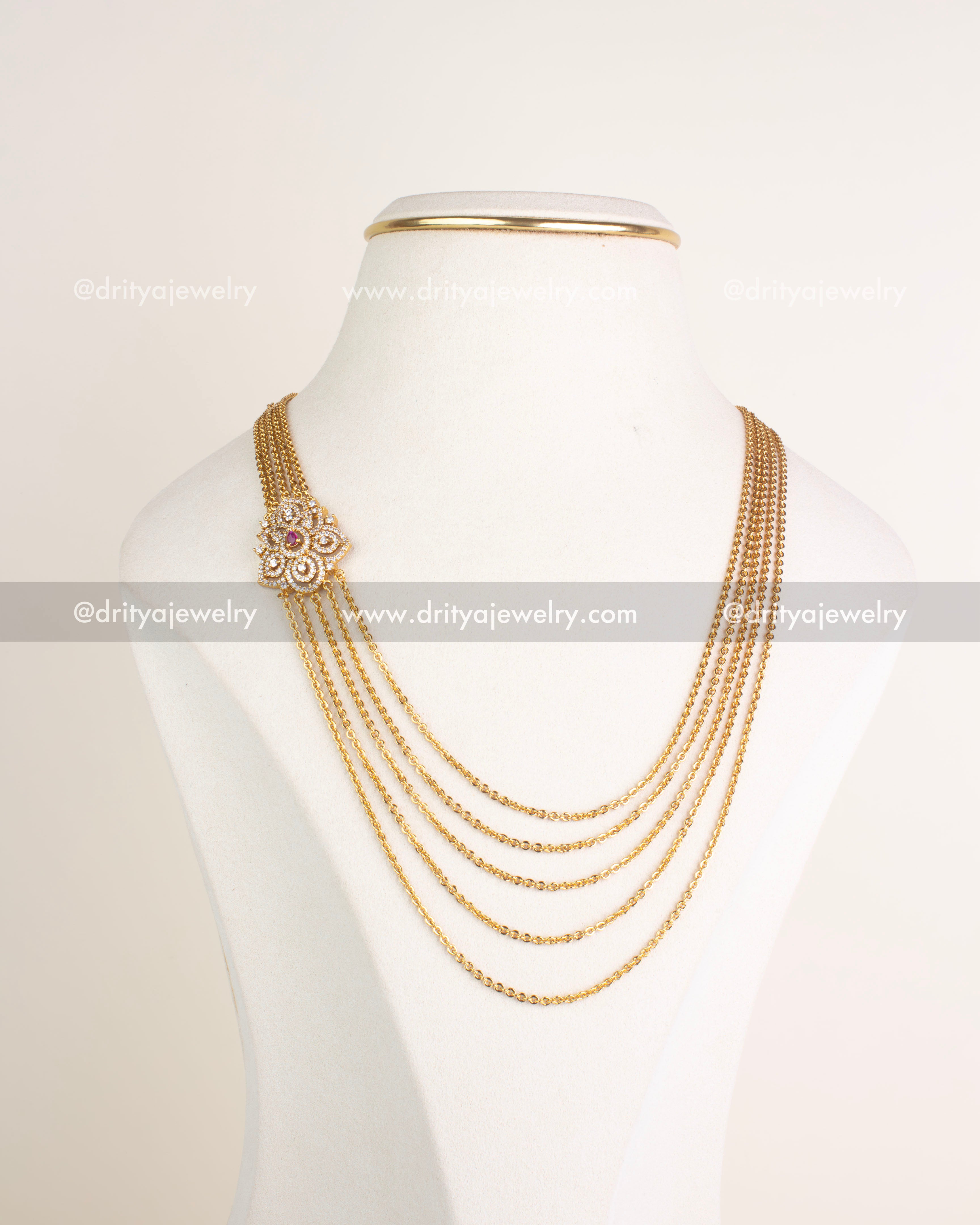 Front view of multi-layered gold-tone chandrahaar necklace with side floral CZ pendant