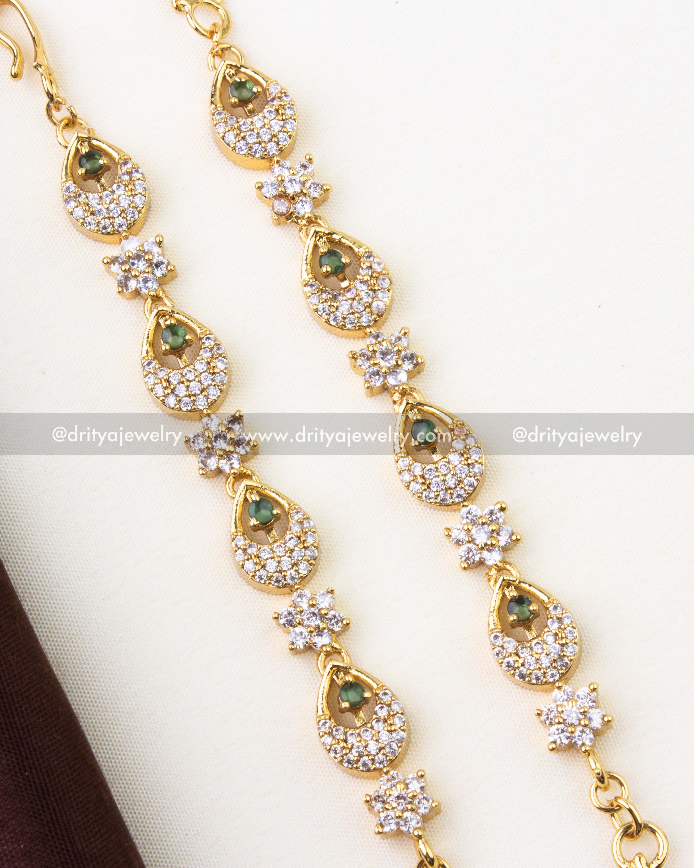 1302-G close-up of teardrop CZ and emerald detailing on gold matilu hair chain