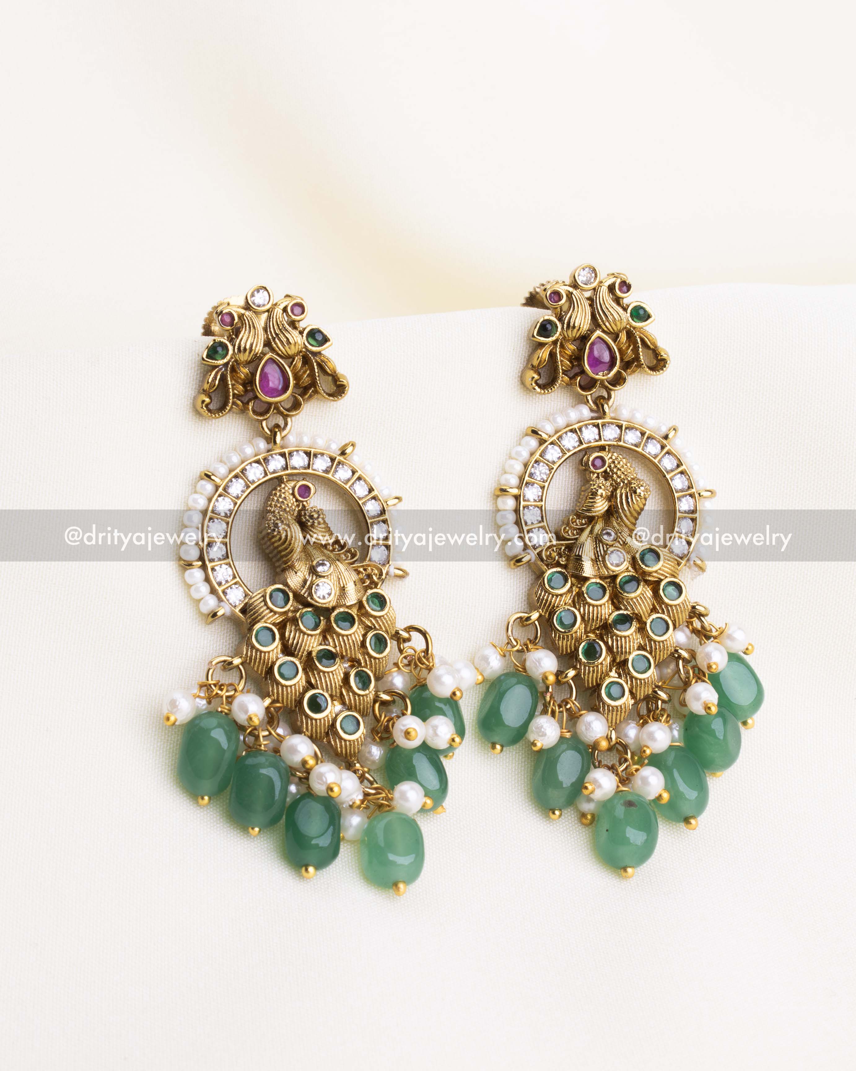 SKU 1108 Necklace Set - Close-up front view of peacock idol earrings with green bead and pearl drops