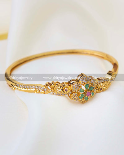 SKU 1256 gold-toned kada bangle with green and ruby floral centerpiece front view