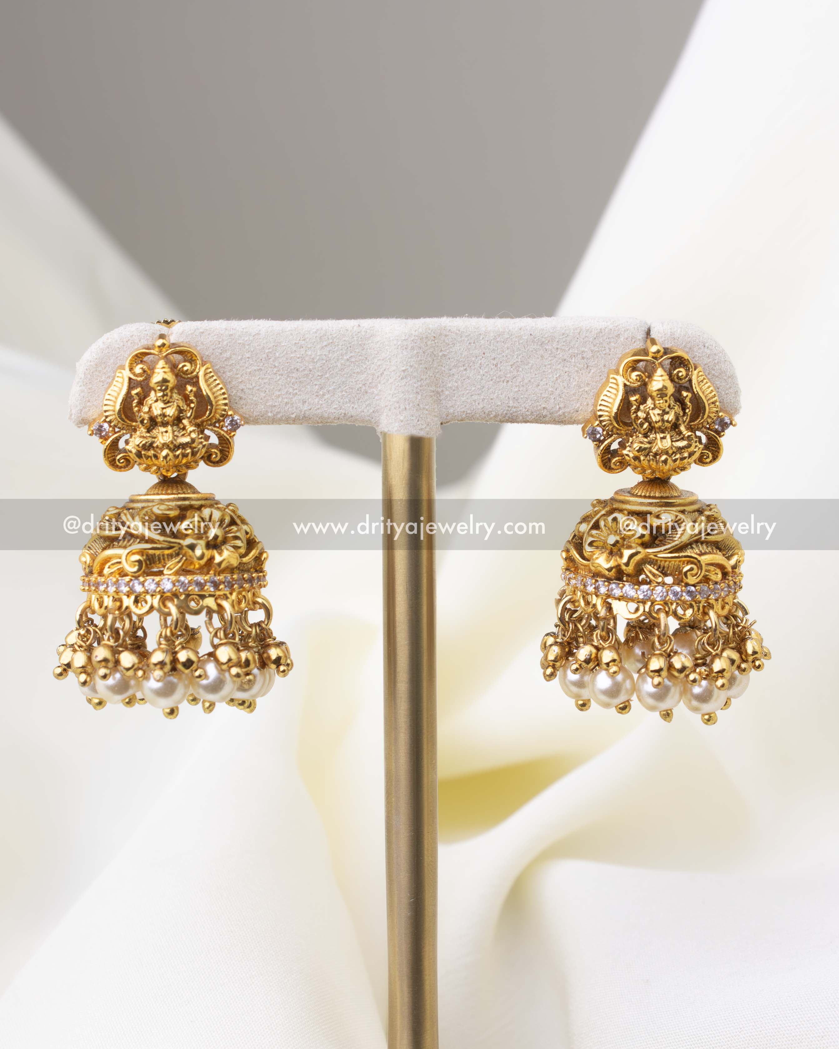 1284-R temple-style Lakshmi jhumka earrings with pearl drops on display stand