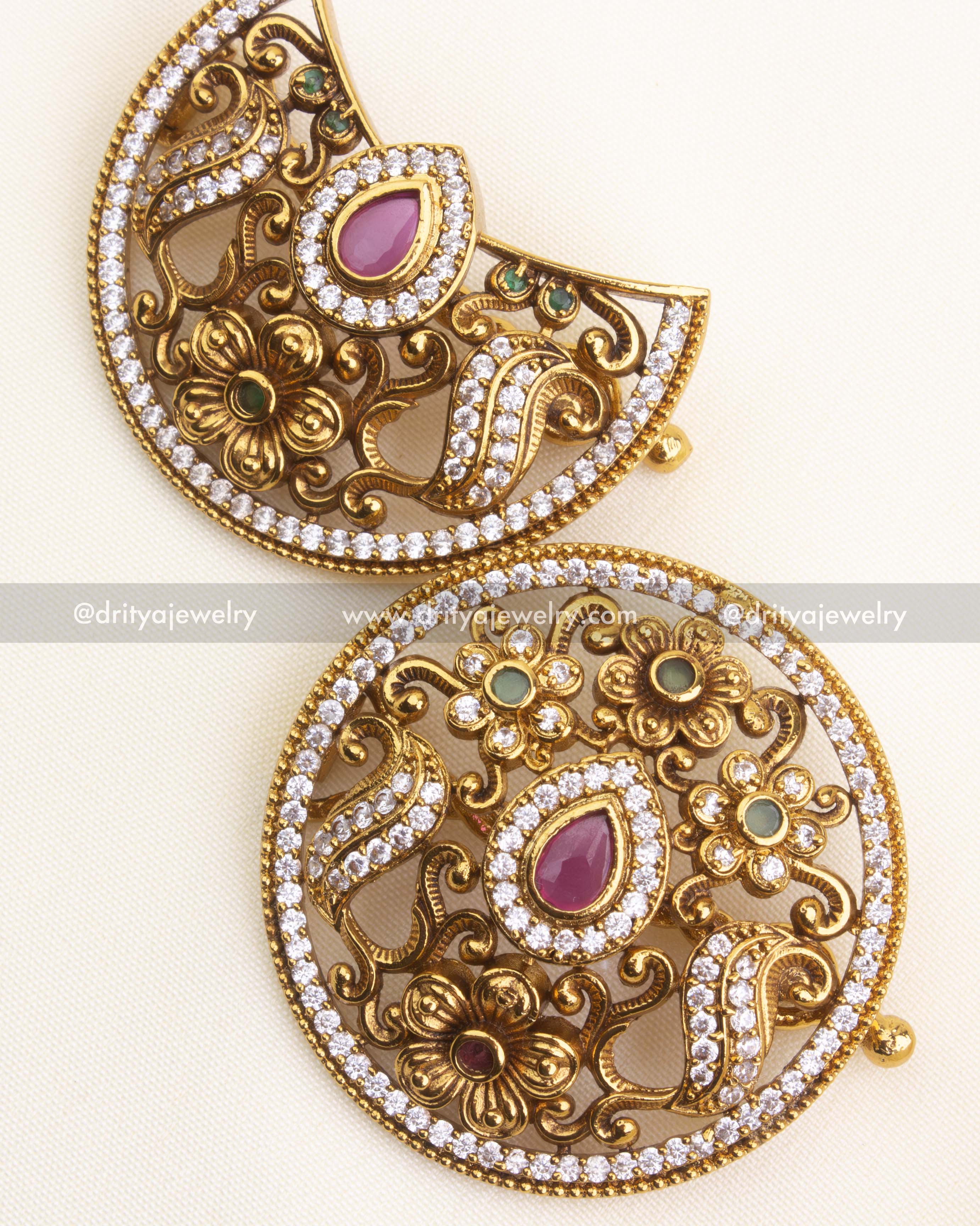 Pair of antique sun and moon hair pins showing ruby-toned centre stones and white stone borders.