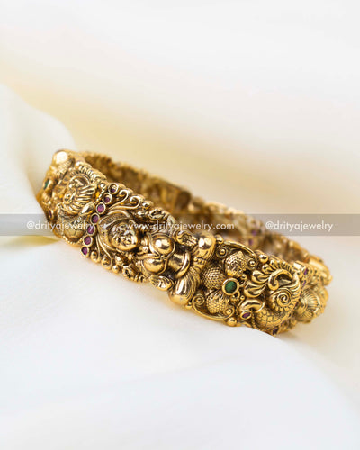 Traditional South Indian bridal kada bangles with peacock motifs and ruby green stone accents